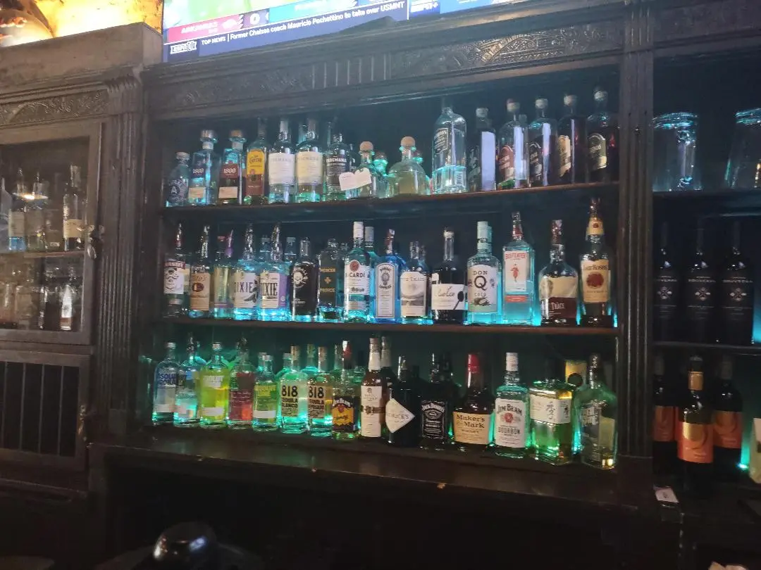 Bottles lit in blues and greens along the back bar shelves at Old Towne Pub